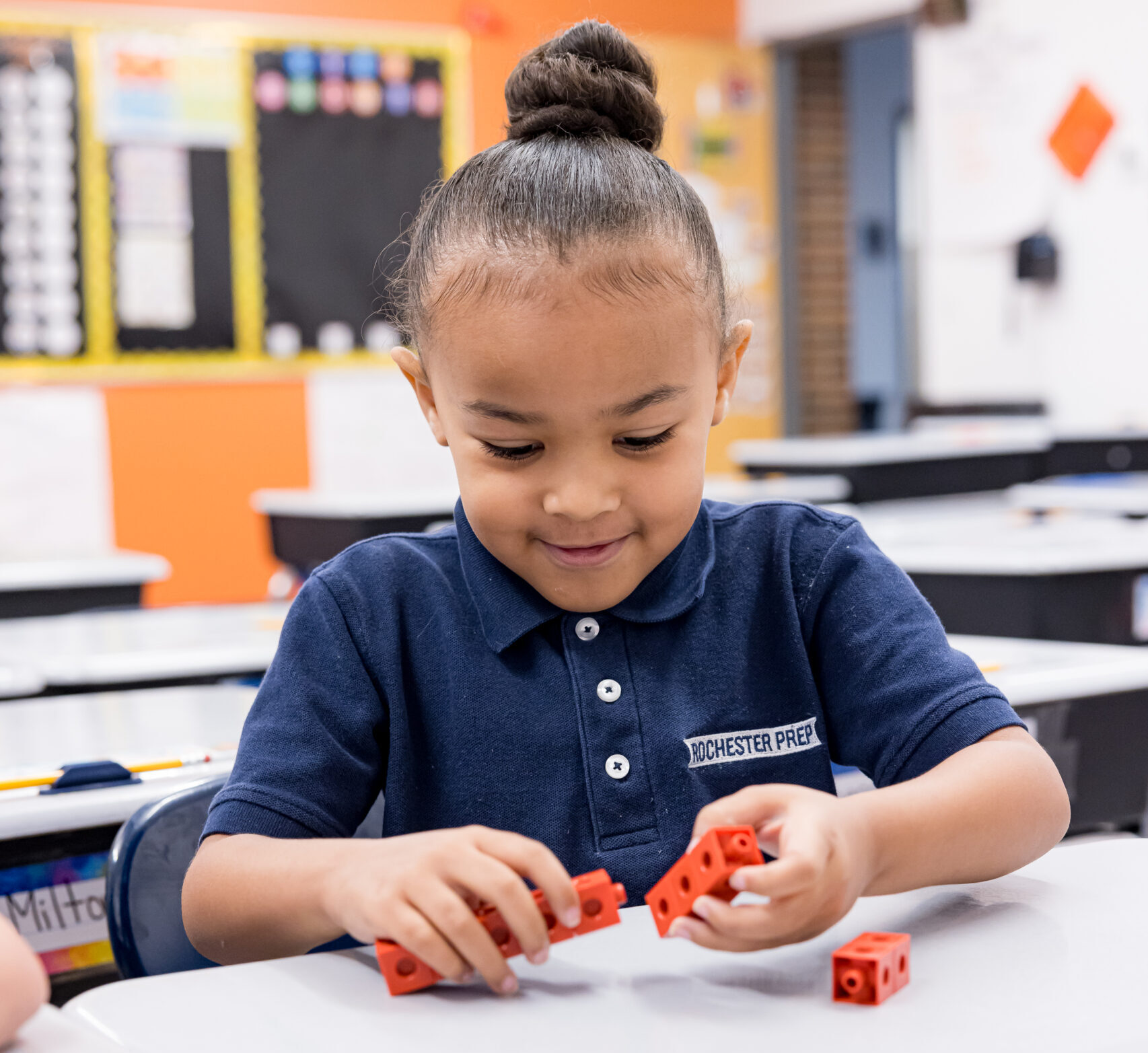 Young student playing with blocks