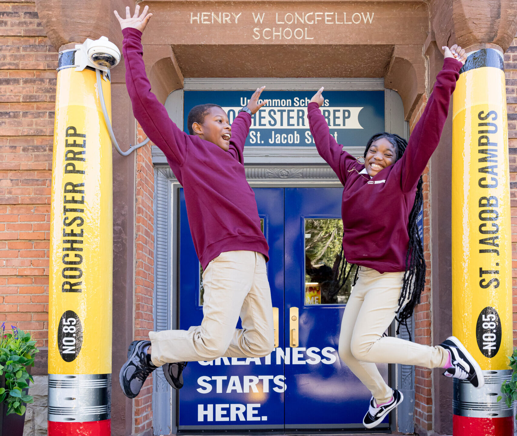 Students jumping in air outside of school building 